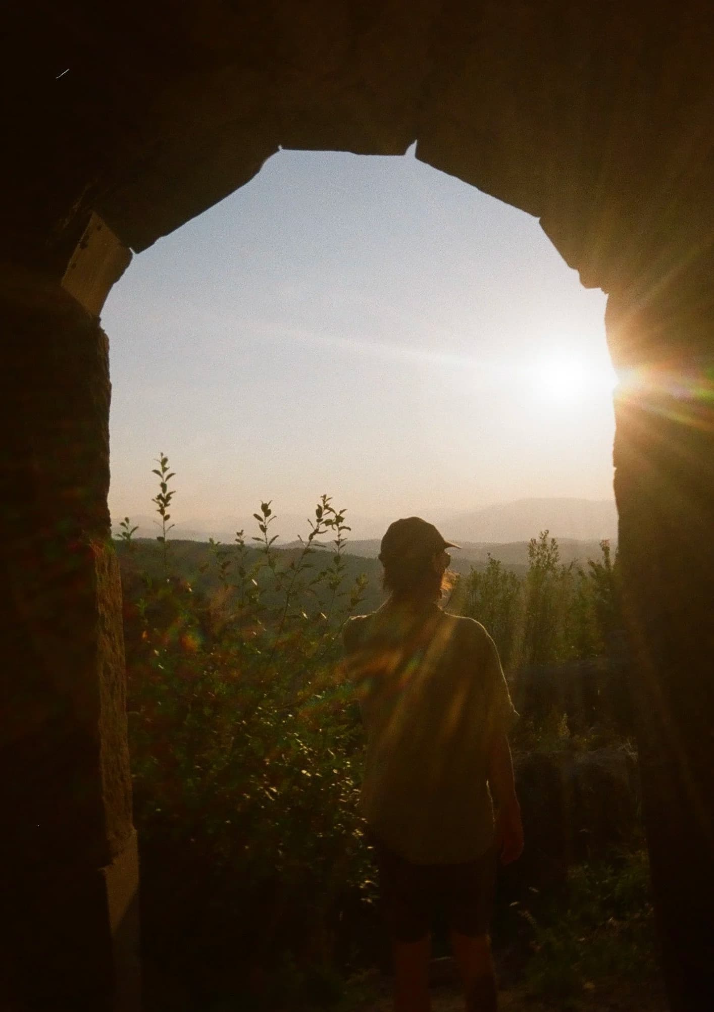 Silhouette through stone archway at golden hour